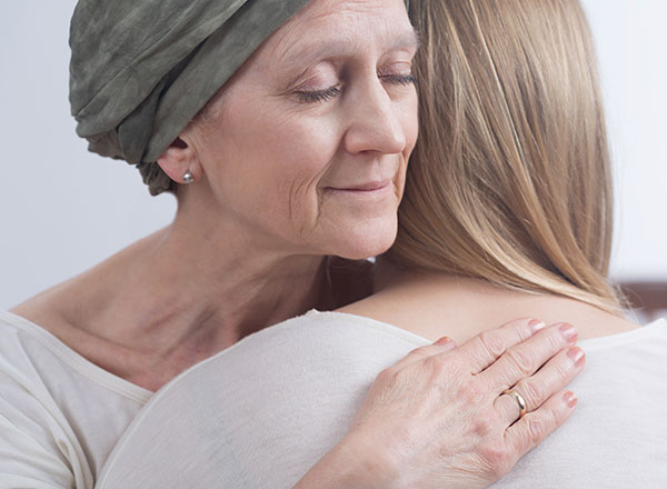 Woman hugging cancer patient
